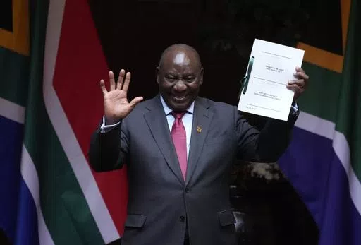 FILE — South African President Cyril Ramaphosa shows the signed bill for National Health Insurance signed into law in Pretoria, South Africa, Wednesday, May 15, 2024. Several polls have the African National Congress' support below 50% ahead of next Wednesday's, May 29, 2024 vote, raising the prospect that it might not be the majority party for the first time since Nelson Mandela led it to victory in the first all-race elections that ended white minority rule in 1994. (AP Photo/Themba Hadebe, F