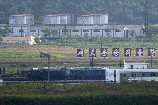 A green train with yellow trimmings, resembling one used by North Korean leader Kim Jong Un on his previous travels, is seen steaming by a slogan which reads "Towards a new victory" on the North Korea border with Russia and China seen from China's Yiyanwang Three Kingdoms viewing platform in Fangchuan in northeastern China's Jilin province on Monday, Sept. 11, 2023. Russia and North Korea confirmed Monday that North Korean leader Kim Jong Un will visit Russia in a highly anticipated meeting with