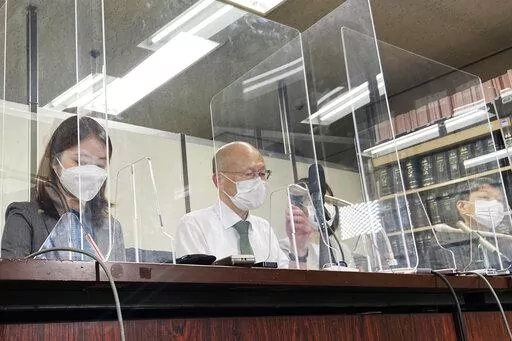 Lawyer Kenichi Ido, second left, sitting among other lawyers representing plaintiffs who were children in Fukushima at the time of the 2011 nuclear disaster and later developed thyroid cancer, speaks during a news conference after a trial in Tokyo, Thursday, May 26, 2022. A Tokyo court began hearing a case Thursday seeking nearly $5 million in damages for six people who lived as children in Fukushima and developed thyroid cancer after its 2011 nuclear disaster. (AP Photo/Mari Yamaguchi)