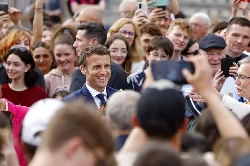 Current French President and centrist presidential candidate for reelection Emmanuel Macron, center, speaks with locals residents about security, in Chatenois, eastern France, Tuesday, April 12, 2022 . Macron, with strong pro-European views, and far-right candidate Marine Le Pen, an anti-immigration nationalist, are facing each other in the presidential runoff on April 24. (AP Photo/Jean-Francois Badias)
