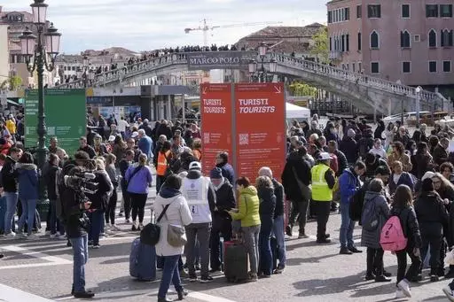 Stewards check tourists QR code access outside the main train station in Venice, Italy, Thursday, April 25, 2024. The fragile lagoon city of Venice begins a pilot program Thursday to charge daytrippers a 5 euro entry fee that authorities hope will discourage tourists from arriving on peak days. The daytripper tax is being tested on 29 days through July, mostly weekends and holidays starting with Italy's Liberation Day holiday Thursday. Officials expect some 10,000 people will pay the fee to acce