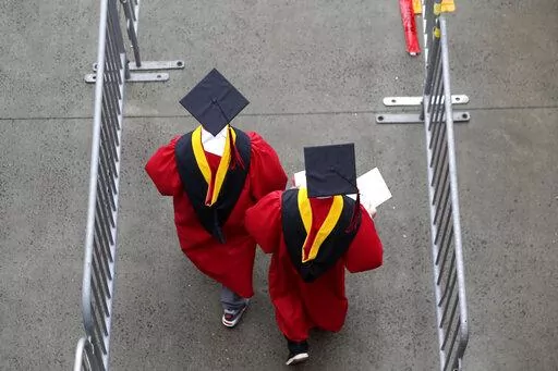New graduates walk into the High Point Solutions Stadium before the start of the Rutgers University graduation ceremony in Piscataway Township, N.J., on May 13, 2018. President Joe Biden’s student loan cancellation offers a life-changing financial break for millions of Americans. But for future students heading to college under the same conditions that created today’s debt, critics say it offers little help. Chief among the causes of today's rising student debt is the cost of college. (AP Ph