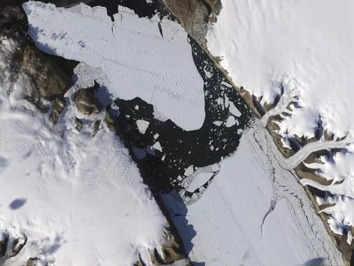 This Aug. 16, 2010, image provided by NASA Earth Observatory shows a piece of the Petermann Glacier that cracked in Greenland. A study in the Proceedings of the National Academy of Sciences on Monday, May 8, 2023, found that tides and climate change are rapidly melting ice in the grounding line zone of the Petermann Glacier. That’s the point where glaciers go from being on land to floating on water. (Jesse Allen and Robert Simmon/NASA Earth Observatory via AP)