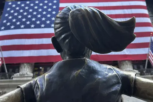 The Fearless Girl statues faces the New York Stock Exchange on July 2, 2024, in New York. Global stocks are mixed on Friday, July 12, 2024, with the Japanese yen losing some of its gains after the latest U.S. update on inflation bolstered Wall Street's belief that relief on interest rates may come as soon as September. (AP Photo/Peter Morgan, File)