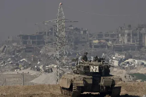 Israeli soldiers overlook the Gaza Strip from a tank, as seen from southern Israel, on Friday, Jan. 19, 2024. (AP Photo/Maya Alleruzzo, File)