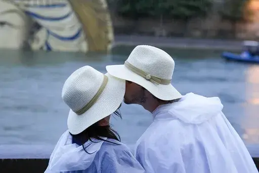 A couple kisses while on the Seine in Paris, France, during the opening ceremony of the 2024 Summer Olympics, Friday, July 26, 2024. Can kissing for six seconds a day lead to a more intimate relationship? That’s what couples therapists John and Julie Gottman say. They have taught thousands of couples therapists that an elongated kiss can help their clients. (AP Photo/Rebecca Blackwell, File)
