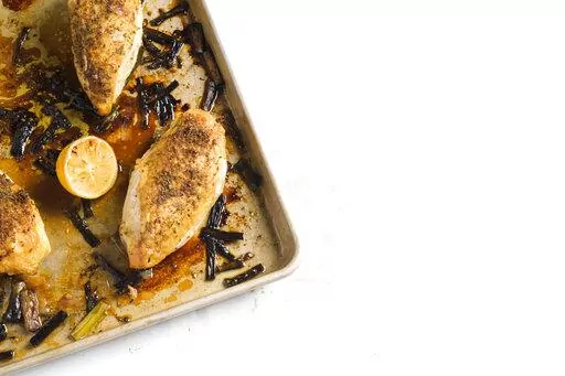 This image released by Milk Street shows a recipe for Fennel-Crusted Chicken & Scallion Traybake. (Milk Street via AP)