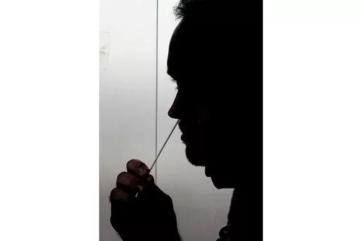 FILE - A rapid COVID-19 test is taken, Wednesday, Nov. 18, 2020, in Salt Lake City. President Joe Biden says the federal government will buy half a billion COVID-19 rapid test kits and distribute them free of charge to people to use at home. Delivery of the first batch of the 500 million tests isn't expected until early January 2022. (AP Photo/Rick Bowmer, File)