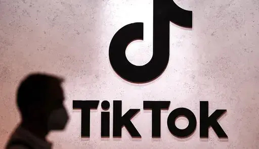 A visitor passes the TikTok exhibition stands at the Gamescom computer gaming fair in Cologne, Germany, Aug. 25, 2022. The European Union's digital policy chief warned TikTok's boss Thursday, Jan. 19, 2023 that the social media app will have to fall in line with tough new rules for online platforms set to take effect later this year. EU Commissioner Thierry Breton held a video call with Shou Zi Chew, the CEO of TikTok, the popular Chinese-owned video sharing app that's coming under increasing sc