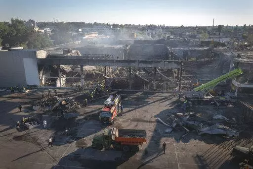 Ukrainian State Emergency Service firefighters work to take away debris at a shopping center burned after a rocket attack in Kremenchuk, Ukraine, Tuesday, June 28, 2022. Residents of the quiet, riverside city of Kremenchuk are reeling in the wake of a Russian airstrike that obliterated a shopping mall and killed at least 18. With dozens still missing, psychologists are working with families to help them through their grief and toward acceptance that they may never find their loved ones. (AP Phot