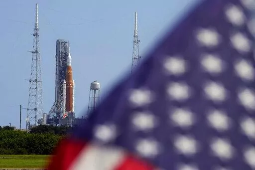 An American flag flies in the breeze as NASA's new moon rocket sits on Launch Pad 39-B after being scrubbed at the Kennedy Space Center Sept. 3, 2022, in Cape Canaveral, Fla.  It’s not just rocket fuel propelling America’s first moonshot after a half-century lull. Rivalry with China’s space program is helping drive NASA’s effort to get back into space in a big way. That's as both nations push to put people back on the moon and establish the first lunar bases. (AP Photo/Chris O'Meara, Fil