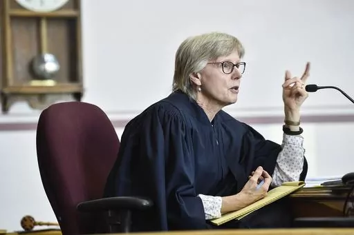 FILE Judge Kathy Seeley listens to arguments during a status hearing for Held vs. Montana in the Lewis and Clark County Courthouse in Helena, Mont., on Friday, May 12, 2023. Seeley dismissed part of the lawsuit filed by young people challenging the state's energy policy after the Legislature repealed it. However, she said a trial is still needed to decide if the rules by which the state evaluates fossil fuel development are constitutional because they don't allow consideration of the effect of g