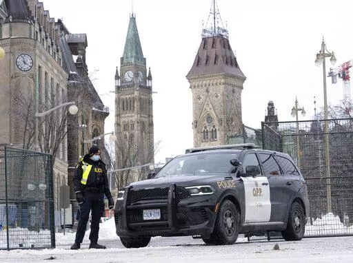 A police officer mans a checkpoint near Parliament Hill, Wednesday, Feb. 23, 2022 in Ottawa. Ottawa protesters who vowed never to give up are largely gone, chased away by police in riot gear in what was the biggest police operation in the nation’s history.  (Adrian Wyld /The Canadian Press via AP)