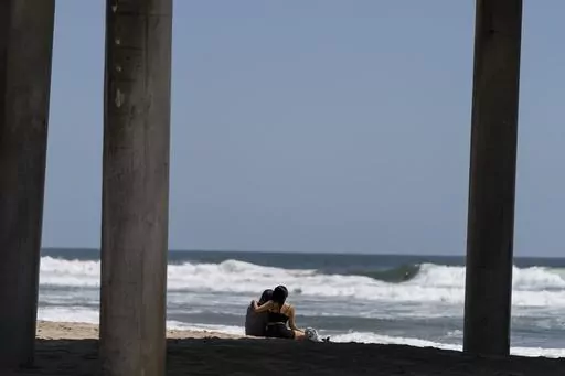 A young couple sit on the beach in Huntington Beach, Calif., Monday, May 8, 2023. For years, studies have shown a decline in the rates of American high school students having sex. That trend continued, not surprisingly, in the first years of the pandemic, according to a recent survey by the Centers for Disease Control and Prevention. The study found that 30% of teens in 2021 said they had ever had sex, down from 38% in 2019 and a huge drop from three decades ago when more than half of teens repo